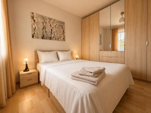 a bedroom with a white bed with towels on it at Monte Carlo Palace Suites in Bucharest