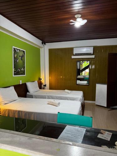 two beds in a room with green walls at hotel le Massilia in Belém