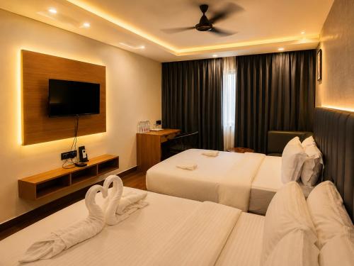 a hotel room with two beds and a flat screen tv at The Saffron Hotel in Bhubaneshwar