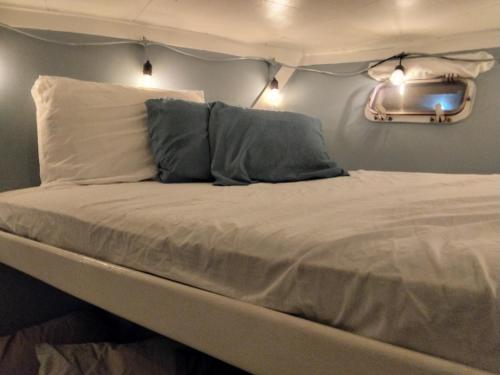 a bed with two pillows and a tv on the wall at party like a local in Key West