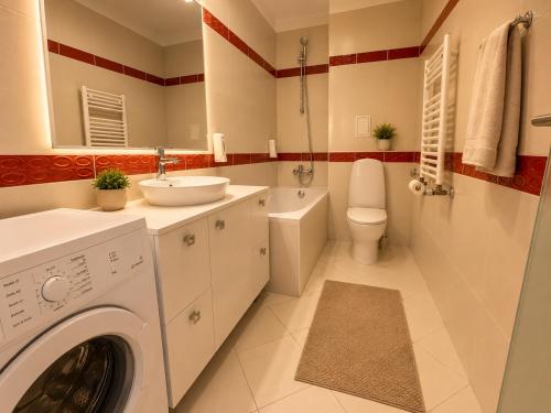 a bathroom with a washing machine and a sink at Monte Carlo Palace Suites in Bucharest