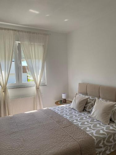 a bedroom with a large bed with a window at Verde Apartment in Banja Luka