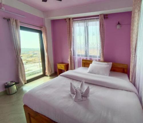 a bedroom with two beds and a large window at La Murphy Homestay in Cherrapunji