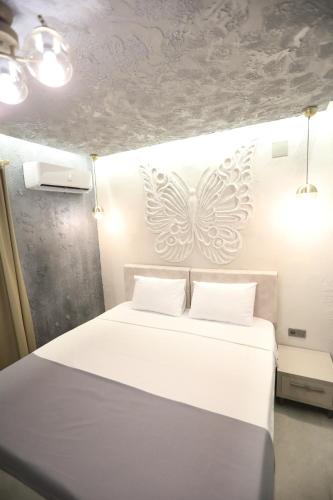a bedroom with a white bed with two white butterflies on the wall at Italy hotel in Silifke
