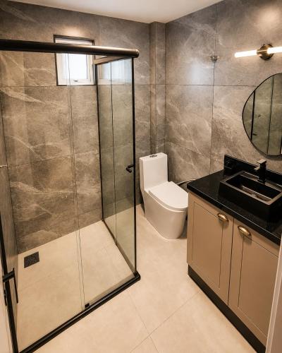 a bathroom with a shower and a toilet and a sink at AP Central Aconchegante 03 Quartos Próx Unimed Com Garagem, Ar Quente Frio, Cozinha Completa - Até 06 Pessoas in Chapecó