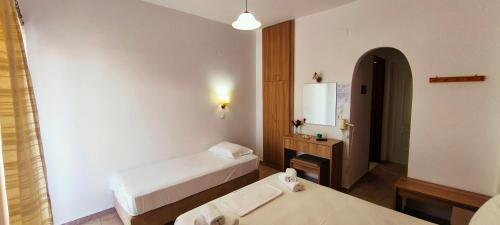 a hotel room with two beds and a mirror at Ragias Studios in Tsilivi