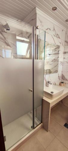a bathroom with a glass shower and a sink at Ragias Studios in Tsilivi