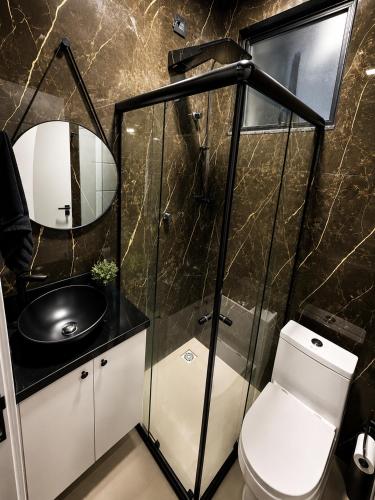 a bathroom with a toilet and a sink at Studio Moderno e Novo - Cozinha Completa, Ar Condicionado e Wifi - Rápido Acesso ao Centro in Chapecó