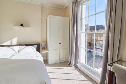 a bedroom with a bed and a large window at Coastal charm in Herne Bay