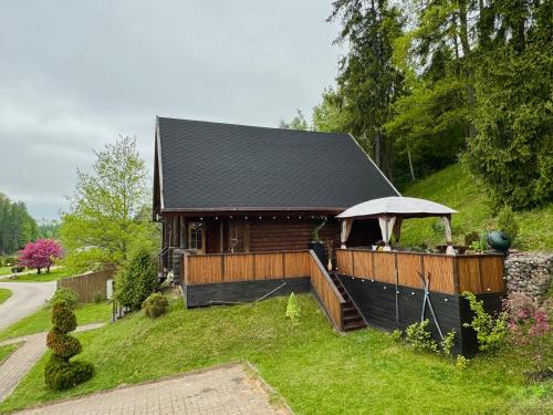 a log cabin with a porch and a roof at Kelgumäe in Otepää