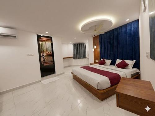 a bedroom with a bed and a table in it at hotel ak grand in Mangalore