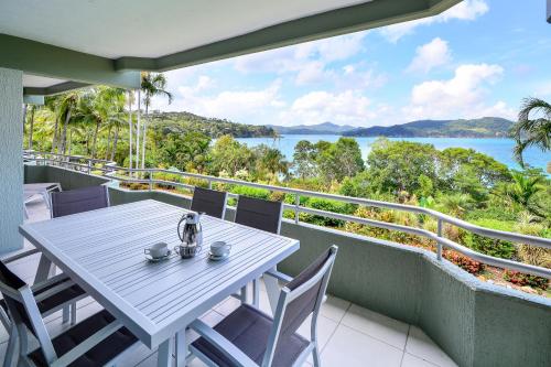 a table on a balcony with a view of the water at Lagoon Apartments on Hamilton Island by HIHA in Hamilton Island
