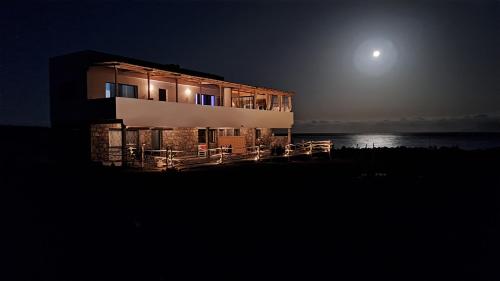 a house at night with the moon behind it at Kasa surf in Porto Novo