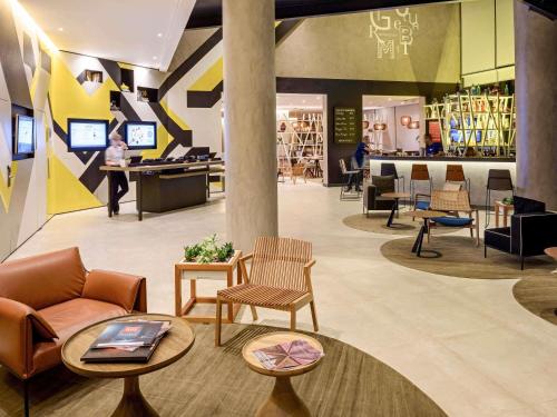 a lobby with chairs and tables in a store at Novotel Sorocaba in Sorocaba
