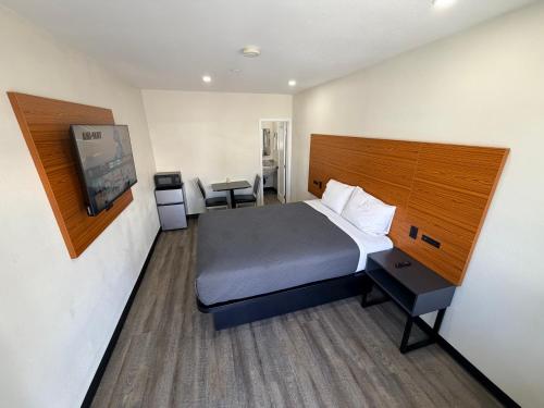 a hotel room with a bed and a flat screen tv at Scenic Motel - El Monte in El Monte