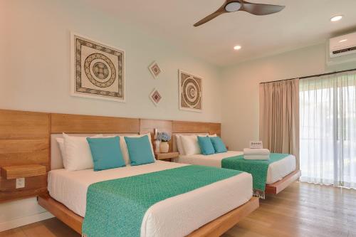 a bedroom with two beds and a window at Hotel Fusión in Puerto Escondido
