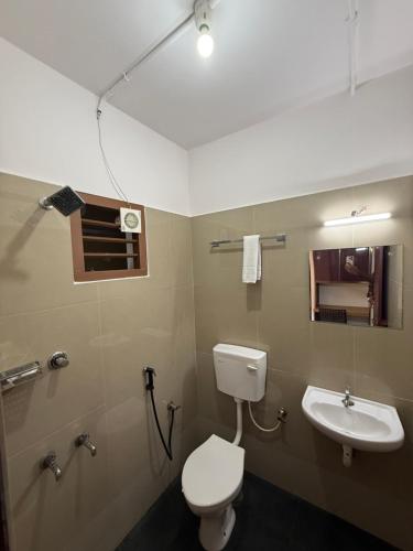 a bathroom with a toilet and a sink at Aero Inn in Nedumbassery