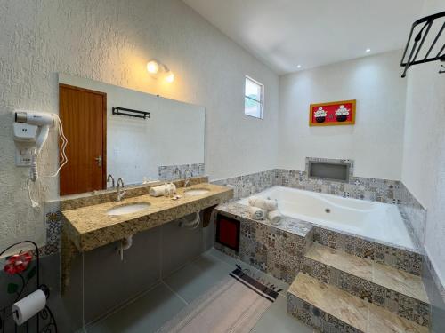 a bathroom with two sinks and a bath tub at Hotel Fazenda Chiminelli in Cachoeiras de Macacu