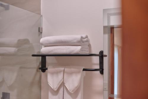 a stack of towels on a towel rack in a bathroom at Hotel Fusión in Puerto Escondido
