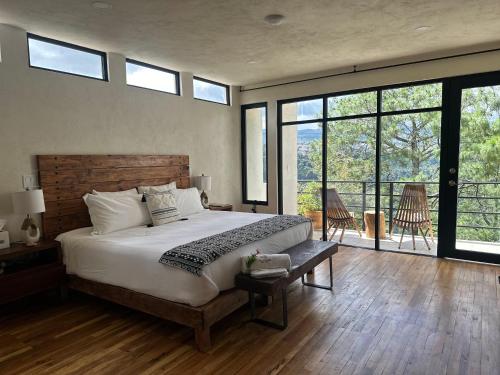 a bedroom with a large bed and windows at Casa Madera Completa in Zacatlán