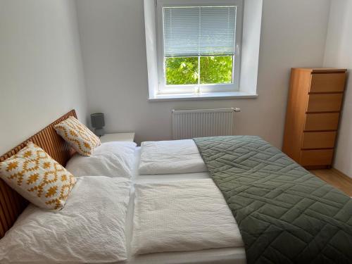 two beds in a bedroom with a window at Karawanken Nest in Feistritz im Rosental