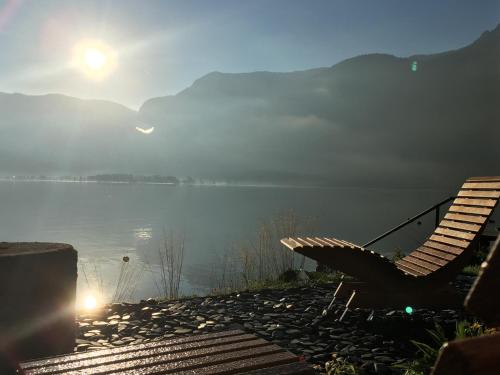 a bench sitting next to a body of water at Hallstatt Hideaway - Adults only in Hallstatt