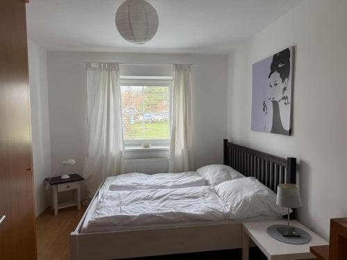 a bedroom with a bed and a window at Karawanken Glück in Feistritz im Rosental