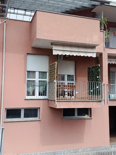 a pink building with a balcony with a dog on it at Ninfa del lago - PRIVATE GARAGE in Colico