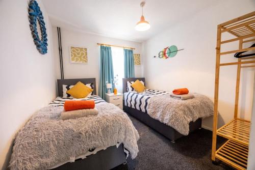 a bedroom with two beds and a mirror at Unique By Monique Kingsholm Bungalow Parking in Gloucester