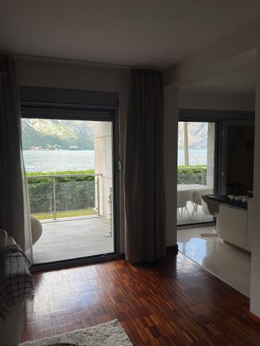 a living room with a sliding glass door with a balcony at Luxury Waterfront Apartment in Boka Bay, Stollywood in Donji Stoliv