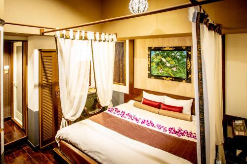 a bedroom with a canopy bed with red pillows at Hotel Balian Resort Kinshicho in Tokyo