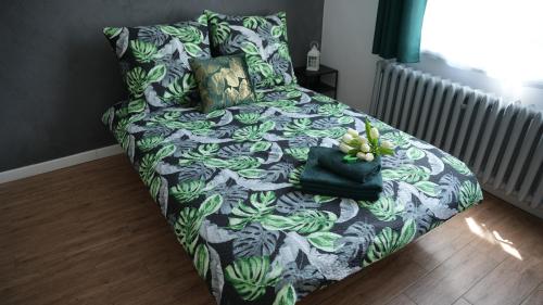 a bed with a black and green blanket and pillows at Pokoje Green House in Ustroń