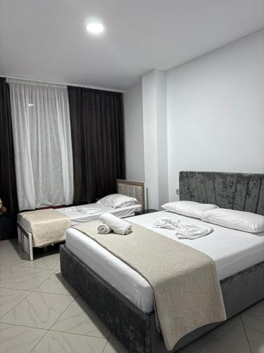 two beds in a hotel room with two bedsvisor at Hotel Kristali in Peshkopi