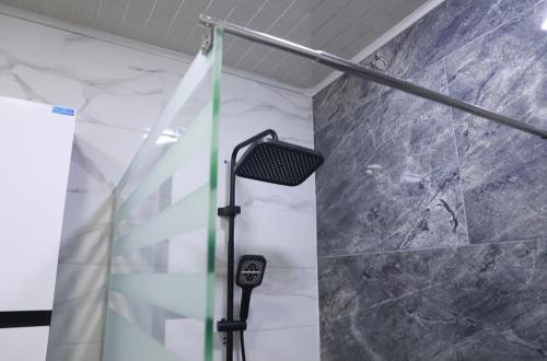 a shower in a bathroom with a stone wall at Belgaid résidence OREVA in Oran