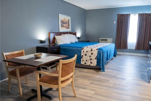a hotel room with a bed and a table and chairs at Highlander Inn Cleveland Beachwood Near I-480 in North Randall