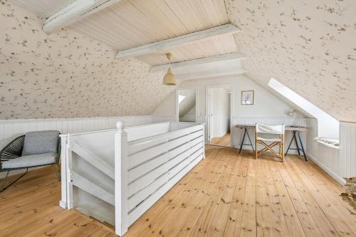 a room with a white wall and a table and chairs at Lakehouse in Vester Vandet