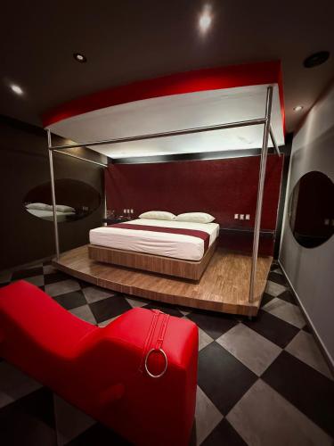 a bedroom with a large bed and a red couch at DLUXE Auto Hotel ADULTS ONLY in Veracruz