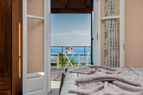 a bedroom with a bed with a view of the ocean at BOHALI'S HOUSE in Agios Gordios