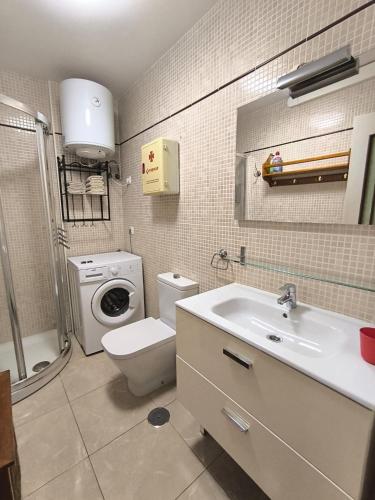 a bathroom with a toilet sink and a washing machine at Apartment Parque Royal Costa Adeje in Adeje