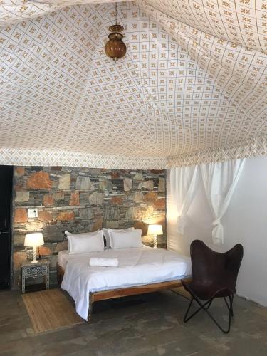 a bedroom with a bed and a stone wall at The chocolate frog in Thūr