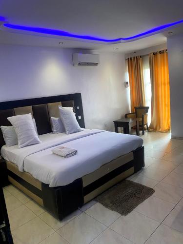 a bedroom with a large bed with a blue ceiling at Mambillah Hotel Ikorodu in Ikorodu