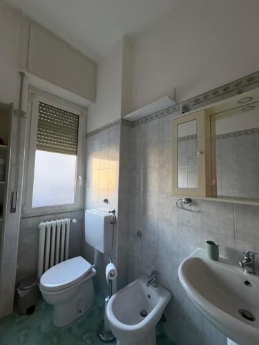 a bathroom with a white toilet and a sink at Casa del Pepo in Segrate