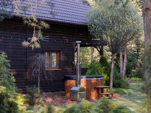 a log cabin with a hot tub in front of it at Domek Hortensja in Zawady