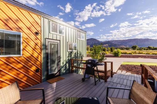 a deck with chairs and a table on a house at Zion Family Adventure Hub Hiking MTB in Apple Valley