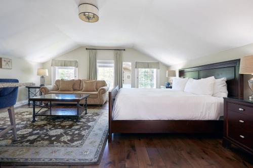 a bedroom with a large bed and a couch at 124 on Queen Hotel & Spa in Niagara-on-the-Lake
