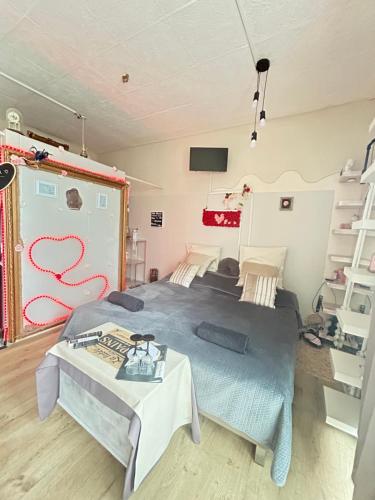 a bedroom with a large bed and a table at Jacuzzi Clim table de massage jardin et barbecue au cœur de Perpignan in Perpignan