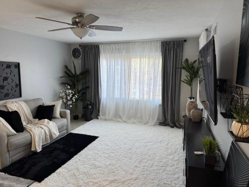 ein Wohnzimmer mit Sofa und Deckenventilator in der Unterkunft Raqsea Condo in Hampton