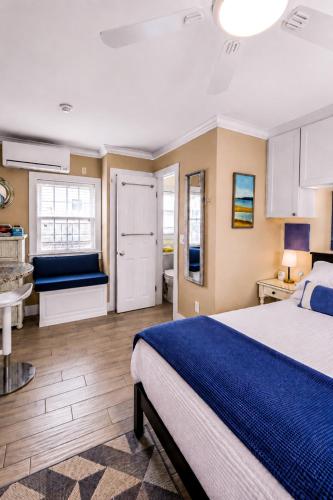 a bedroom with a large bed and a kitchen at Waterfront Studio - Bay Views, Steps to Comm St in Provincetown