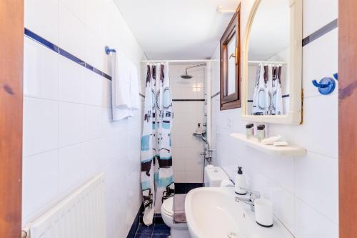 a white bathroom with a sink and a toilet at Demie's Maisonette in Plytra with SeaView in Plytra