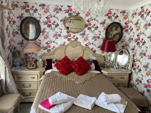 a bedroom with a bed with red pillows and mirrors at Bonnye's guest house in Ramsgate